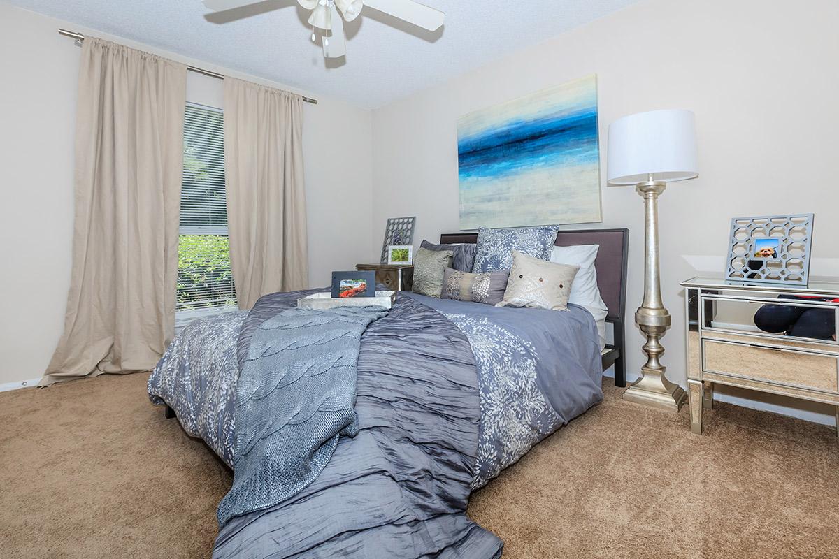 a bedroom with a bed and desk in a room
