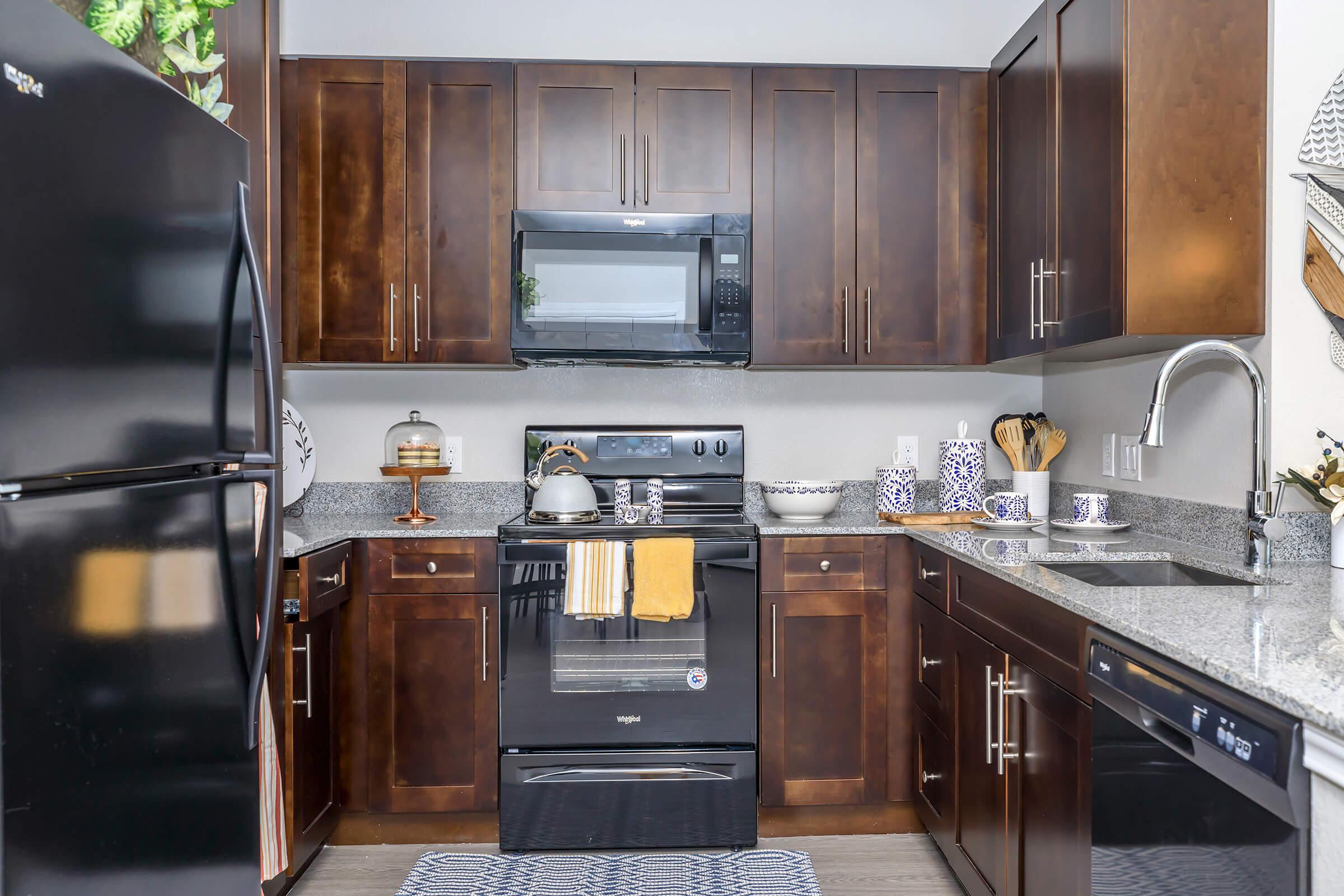 a modern kitchen with stainless steel appliances and wooden cabinets