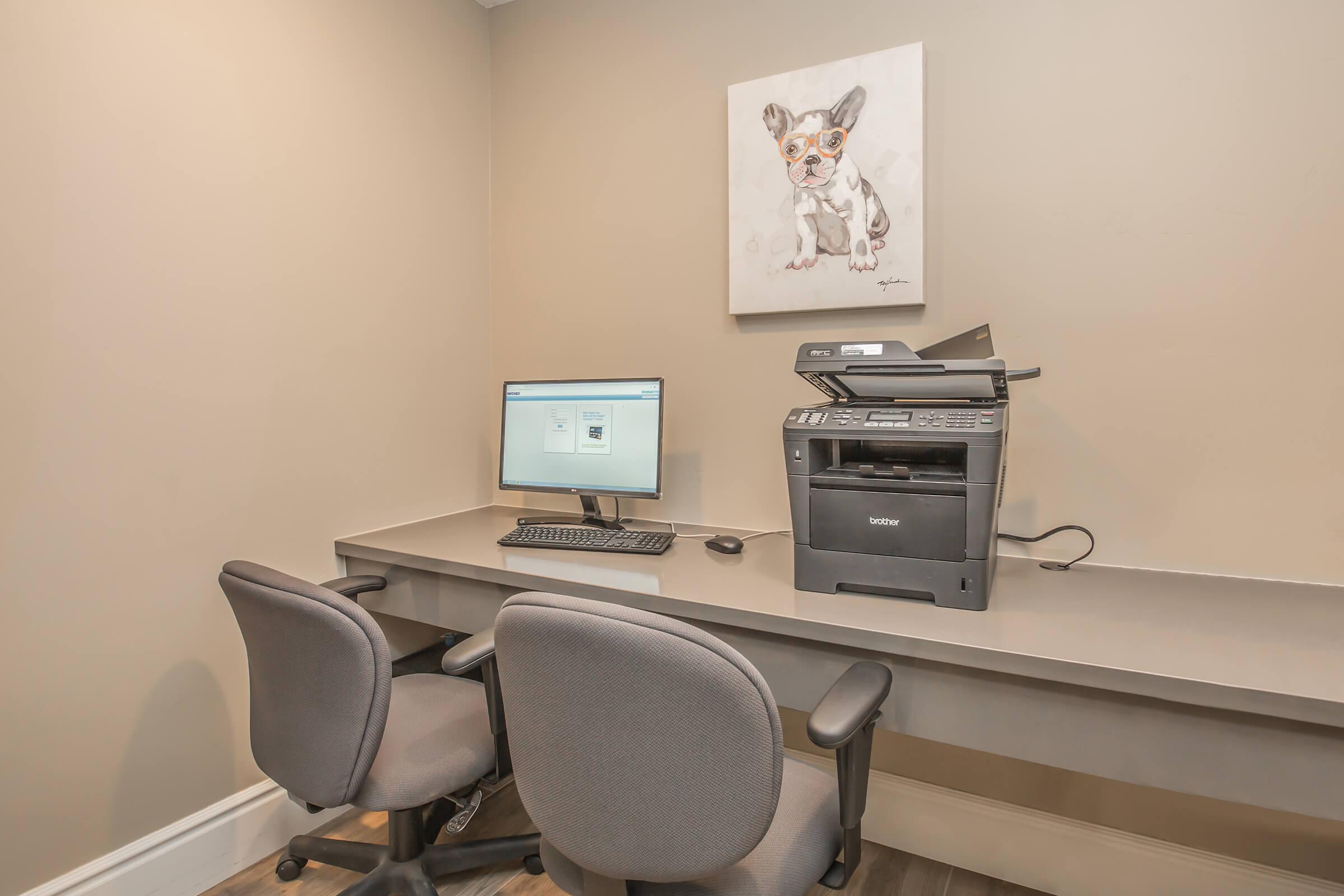 a desk with a computer and a chair in a room