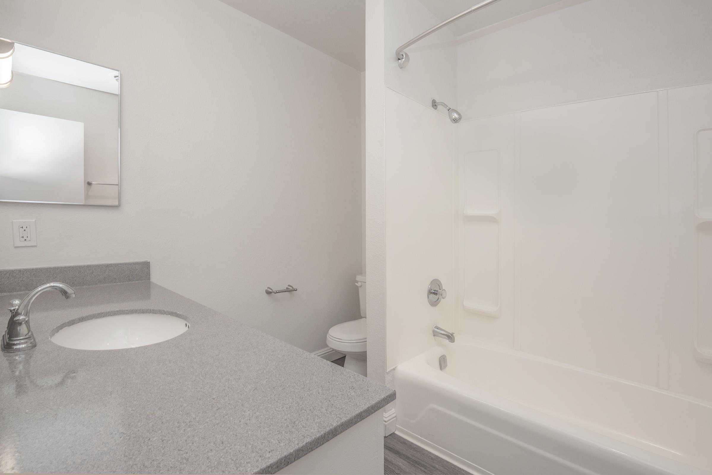 a white sink sitting under a mirror