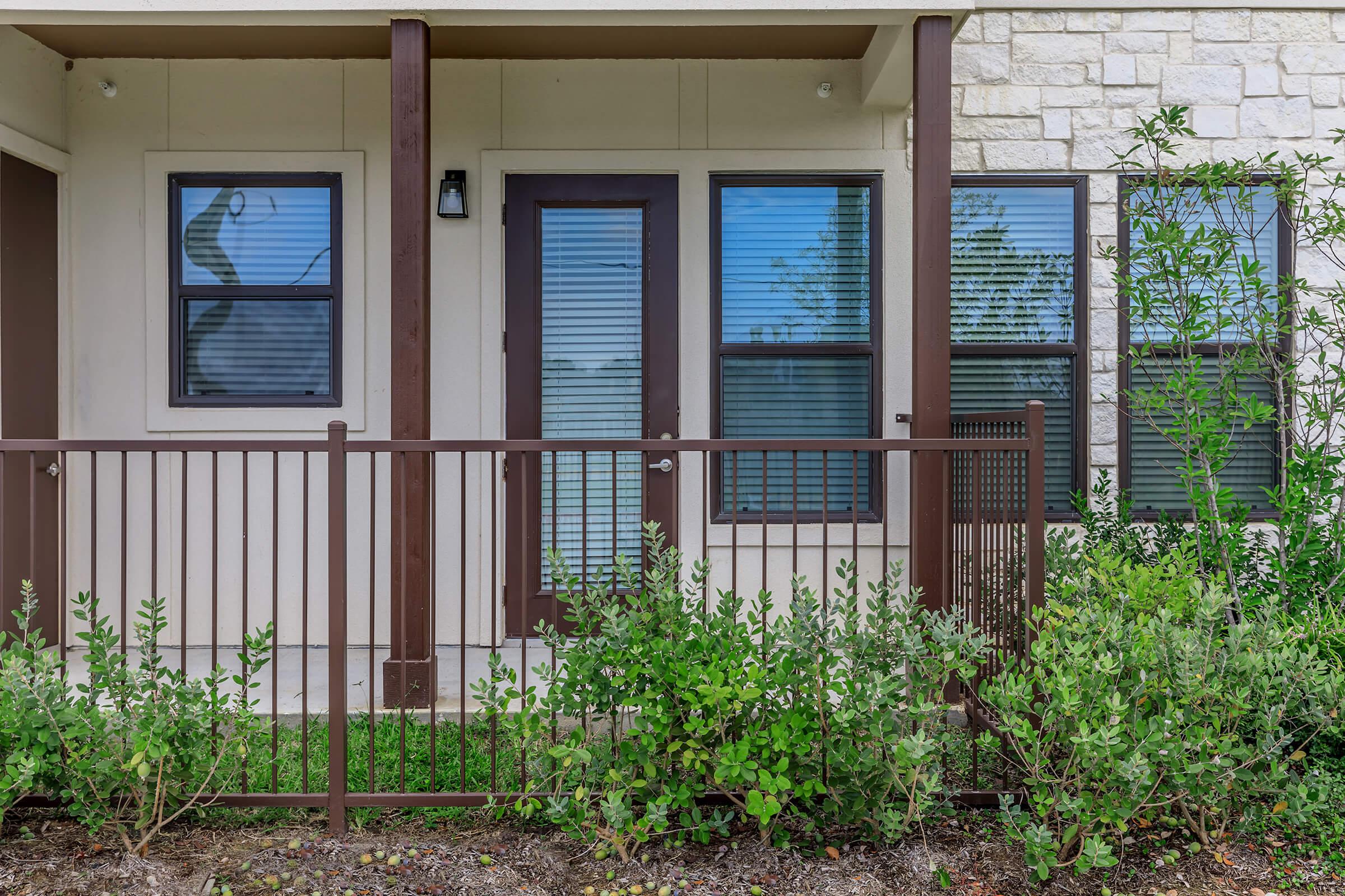 a house with bushes in front of a window