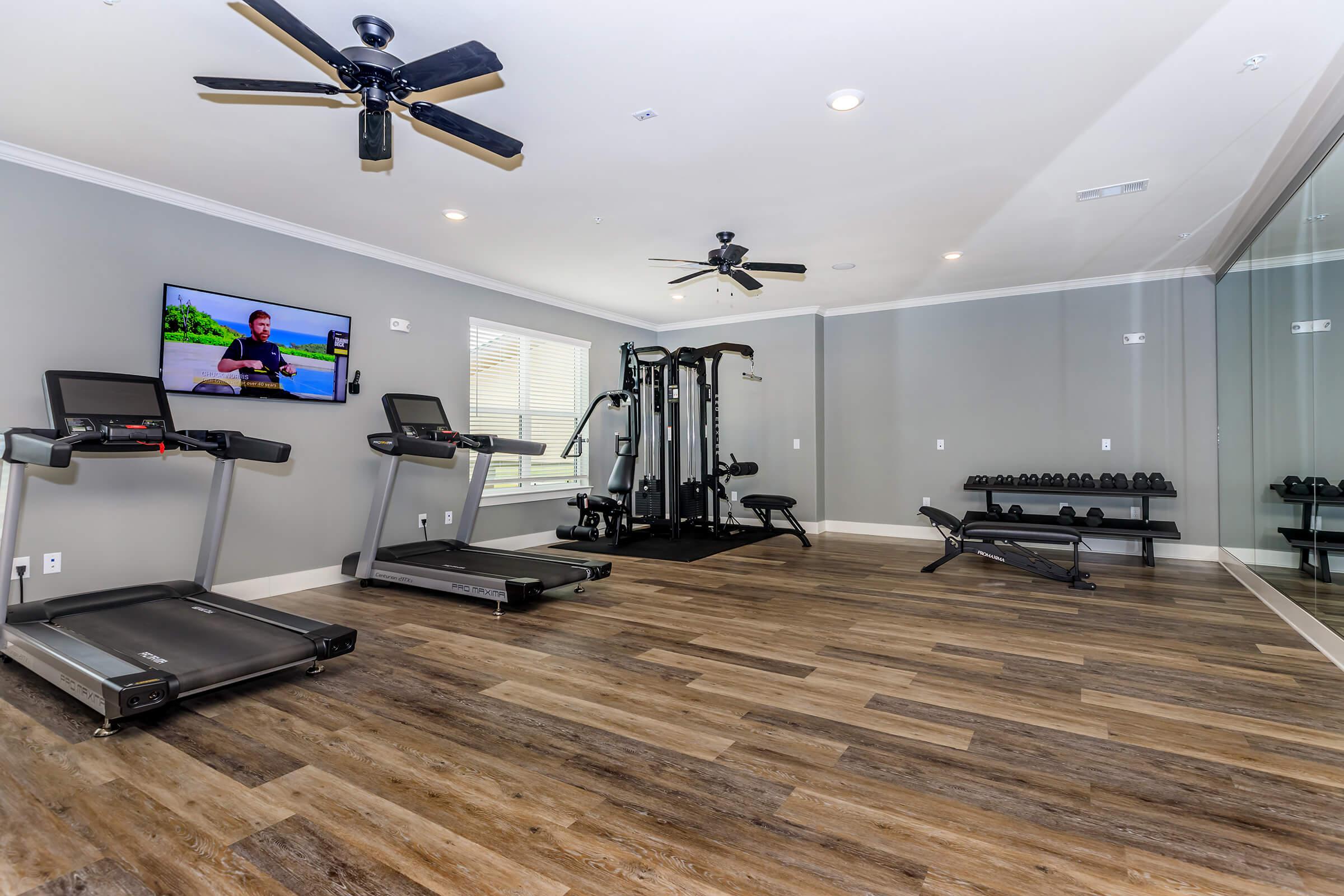 The fitness center at our 55 and over apartments in Spring, TX, featuring wood grain floor paneling 