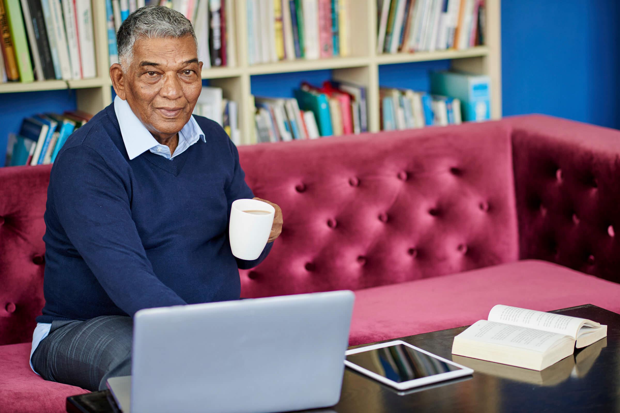 a person sitting at a table with a book shelf