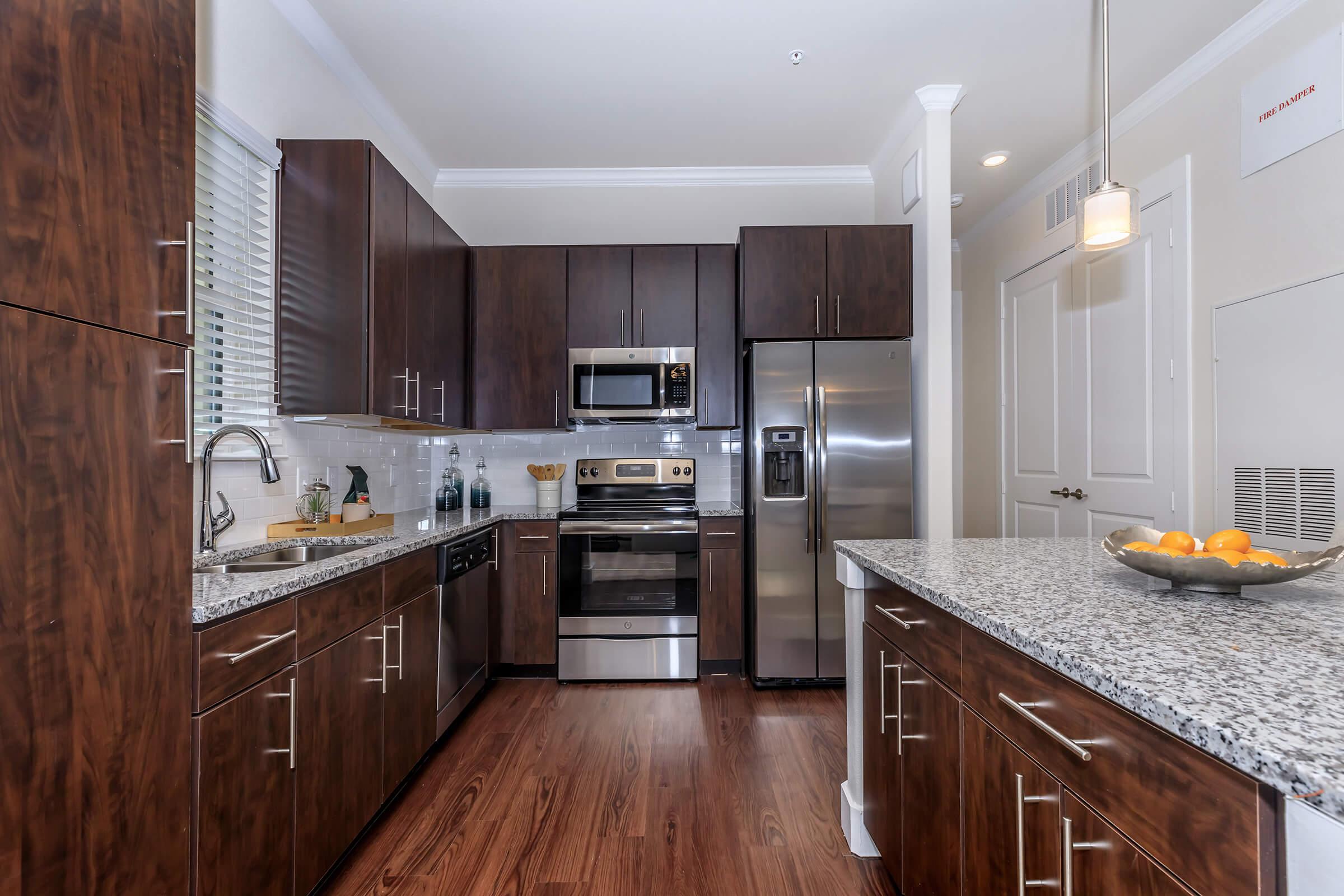 a modern kitchen with stainless steel appliances and wooden cabinets