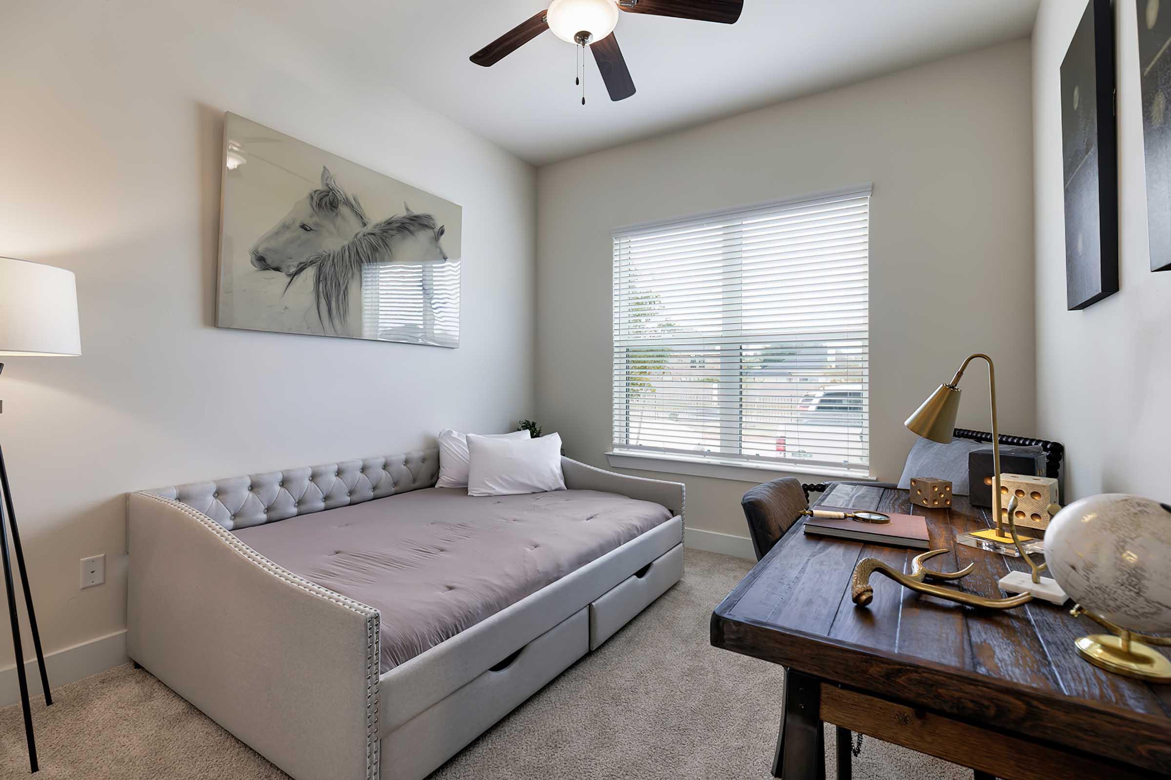 a bedroom with a bed and desk in a room