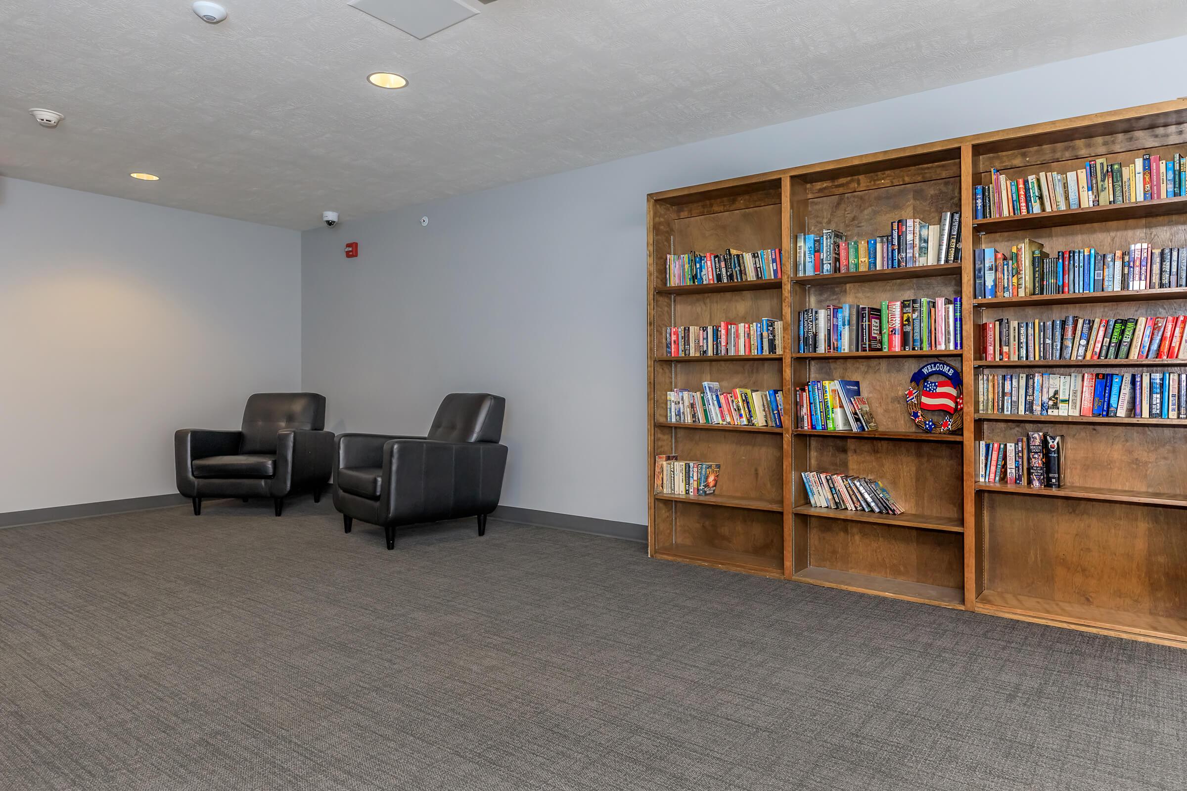 a living room filled with furniture and a book shelf