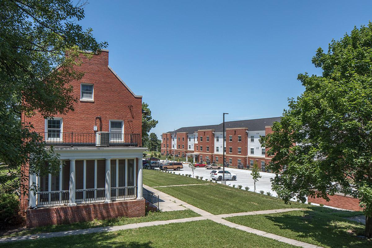 a house with bushes in front of a brick building