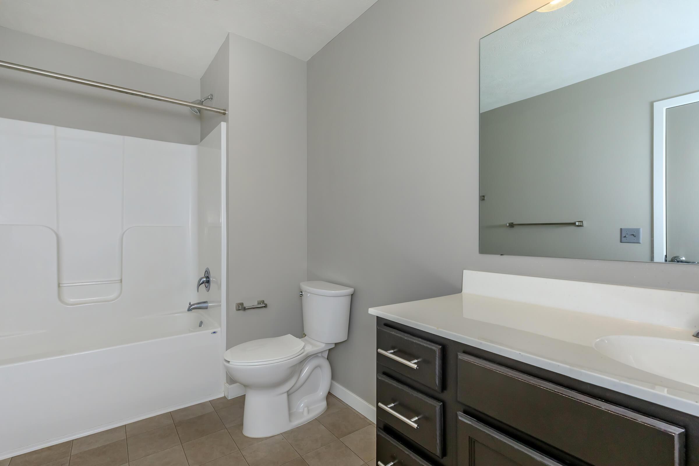 a white sink sitting under a mirror