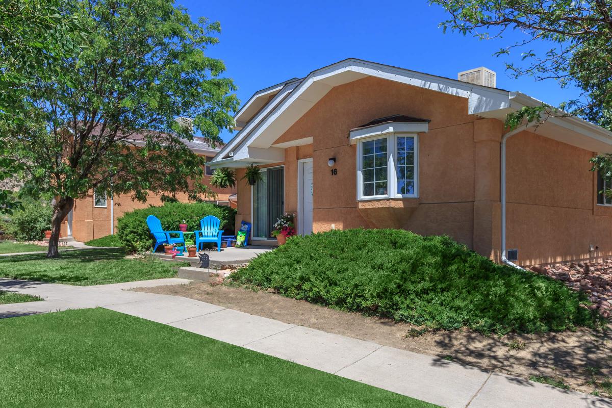 a house with a lawn in front of a brick building