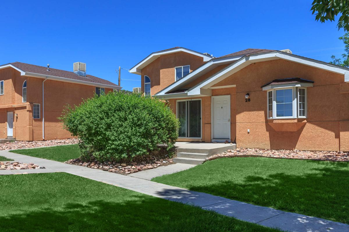 a large brick building with grass in front of a house