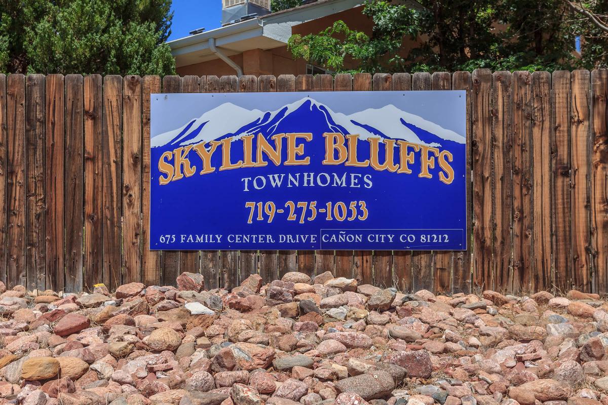 a sign in front of a rock