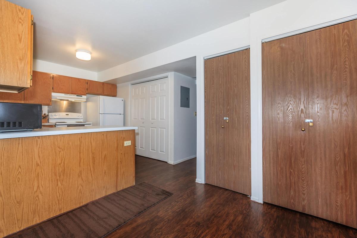 a kitchen with wooden cabinets and a wood floor