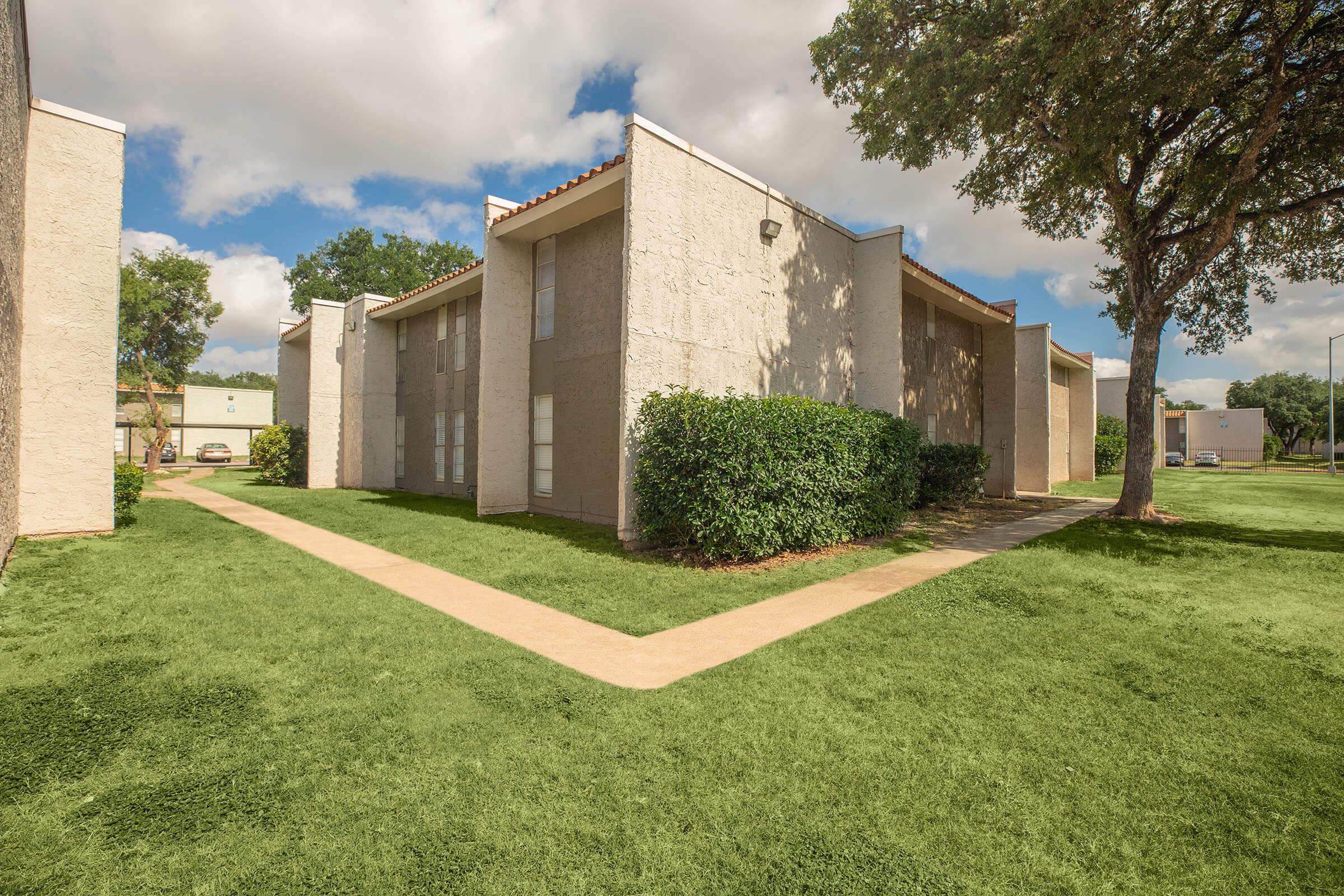 a large lawn in front of a brick building