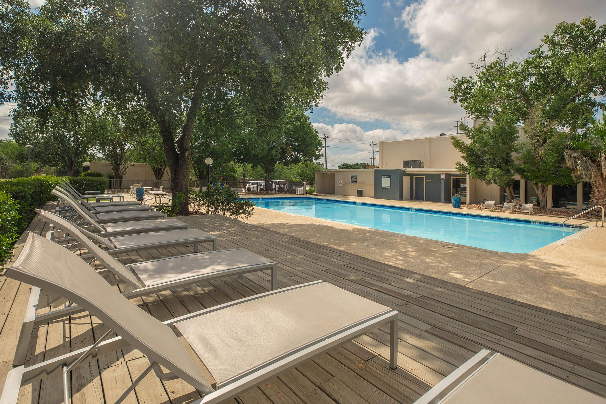 an empty park bench next to a pool