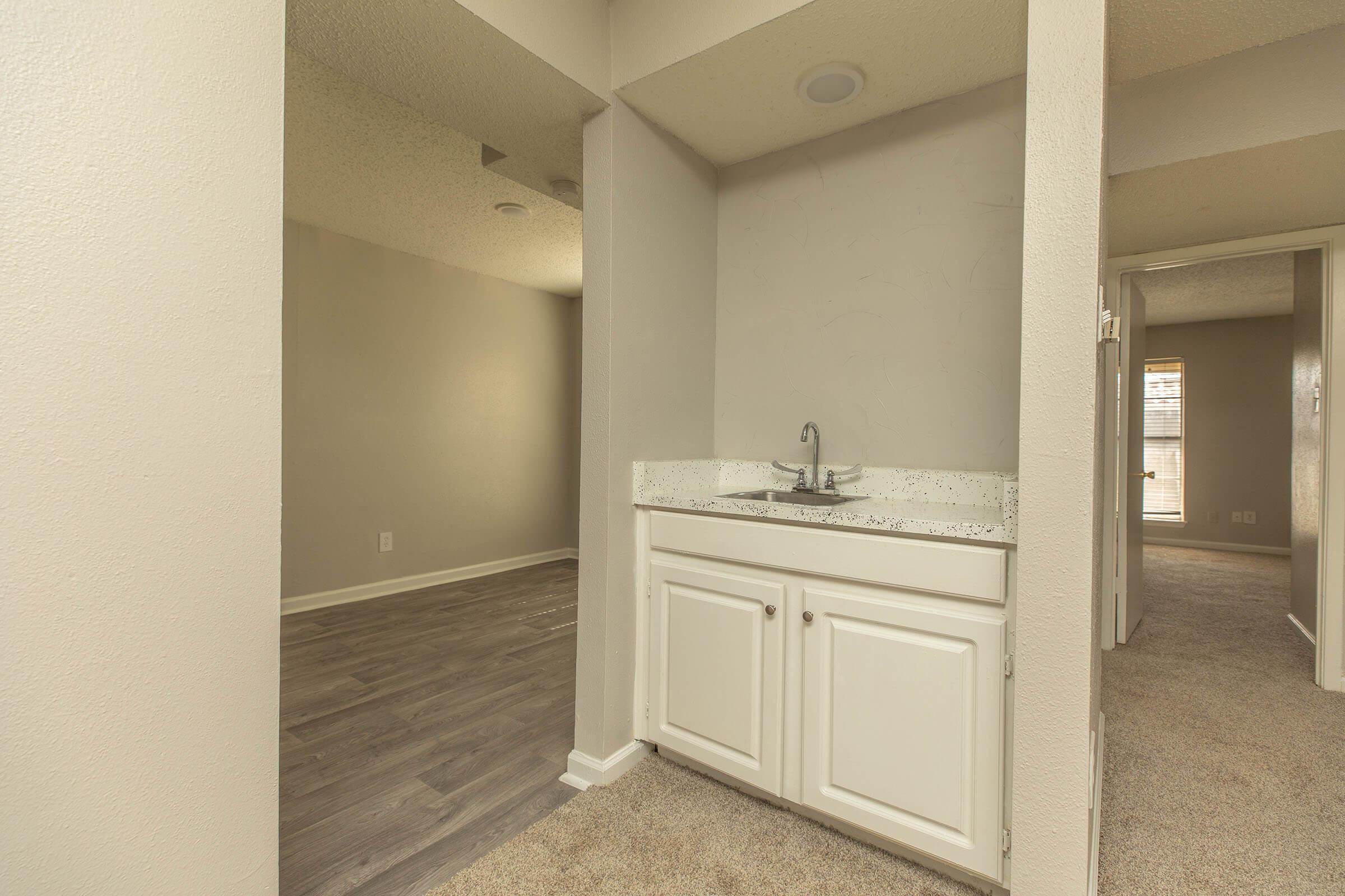 a large empty room with a sink and a mirror