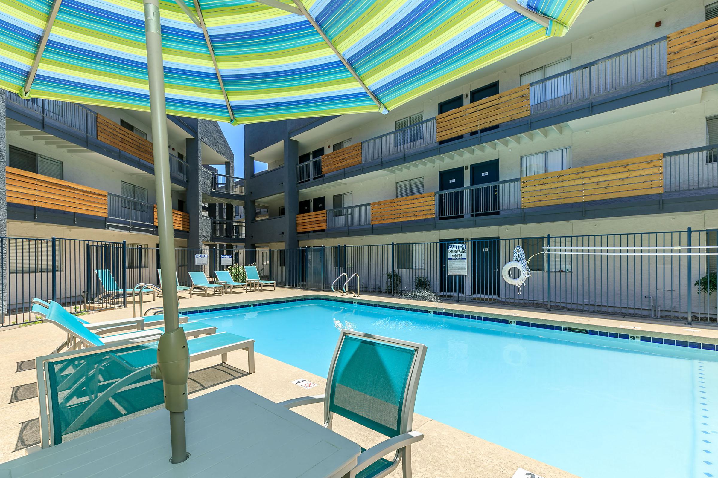 Resort style outdoor pool under a 3 story apartment building