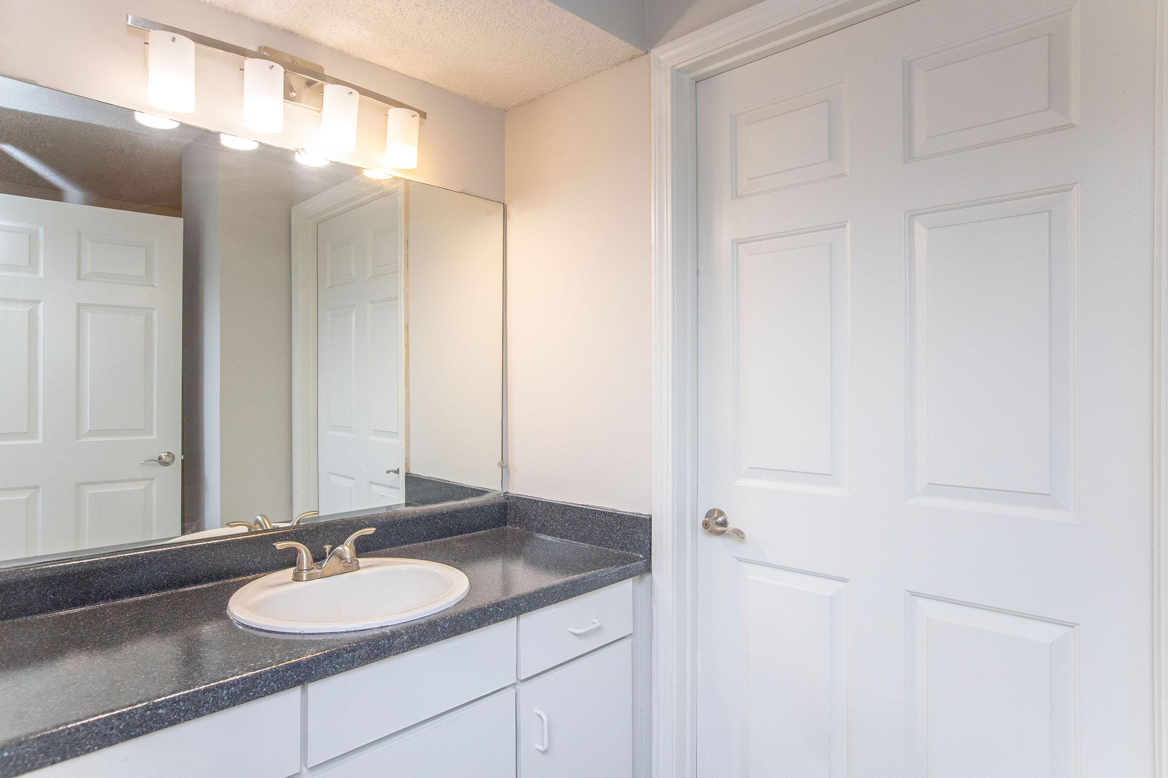 a kitchen with a sink and a mirror