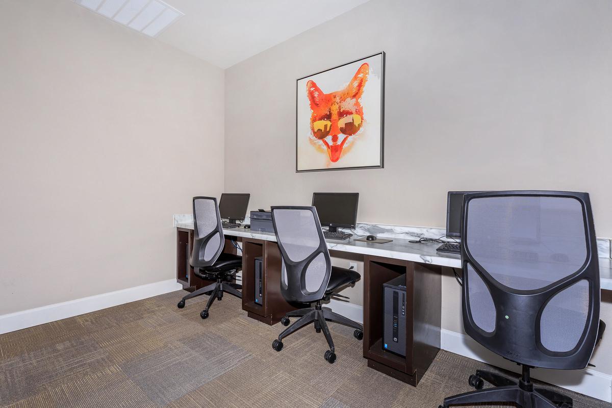 a desk with a computer and a chair in a room