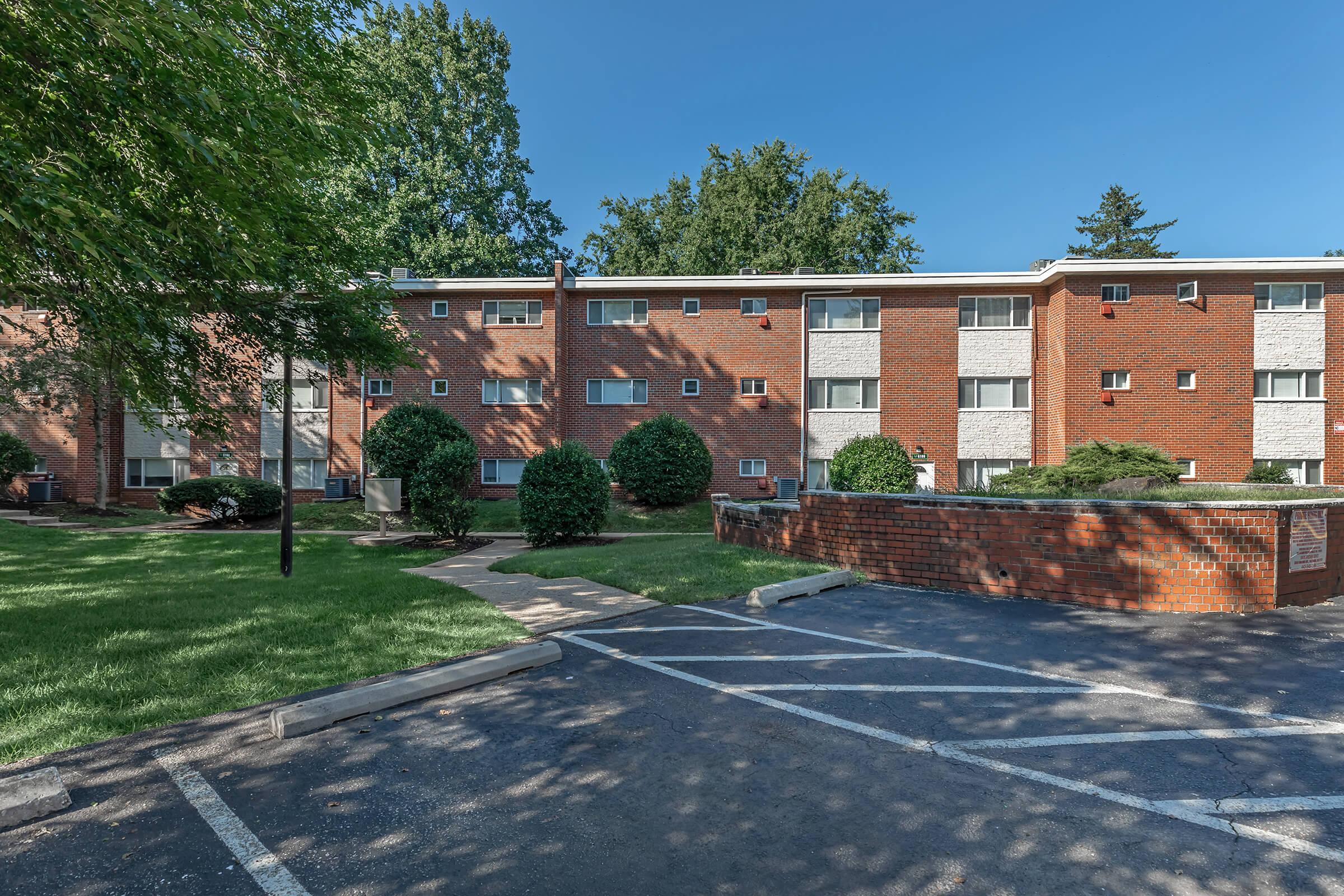 an empty parking lot in front of a brick building