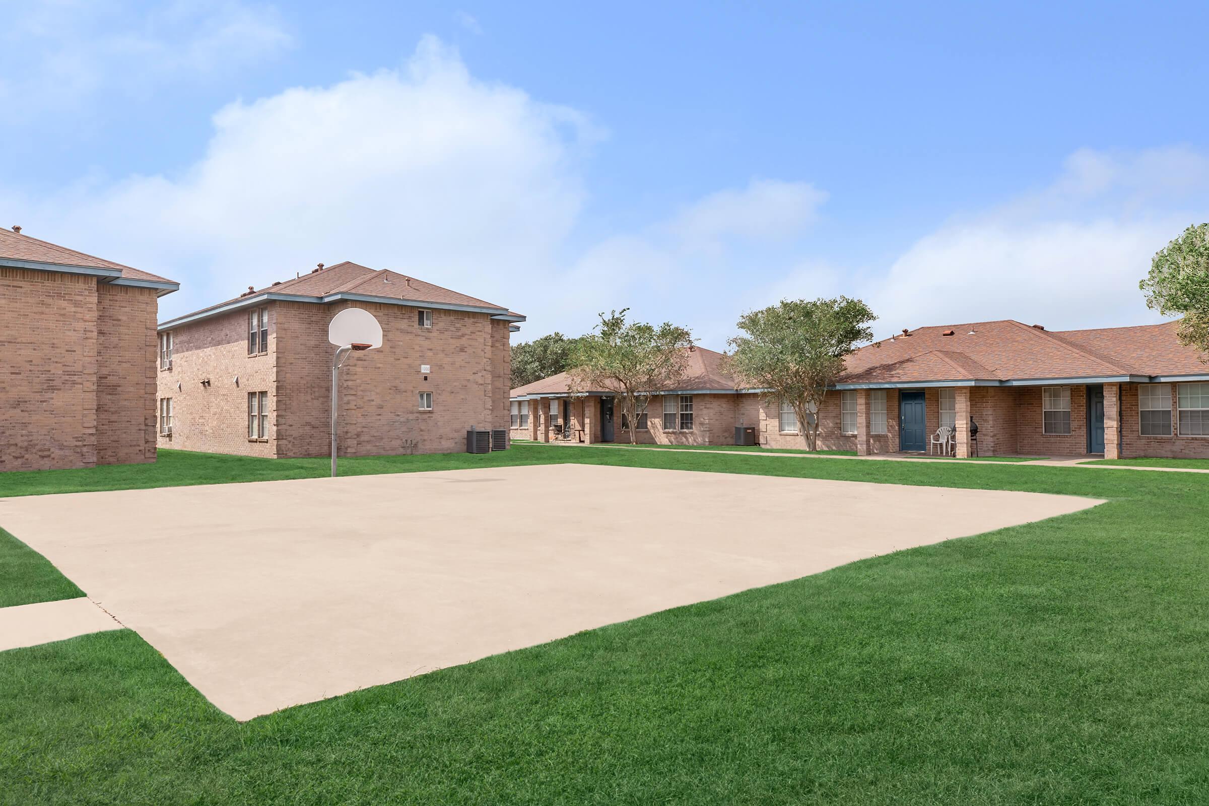 a large brick building with grass in front of a house