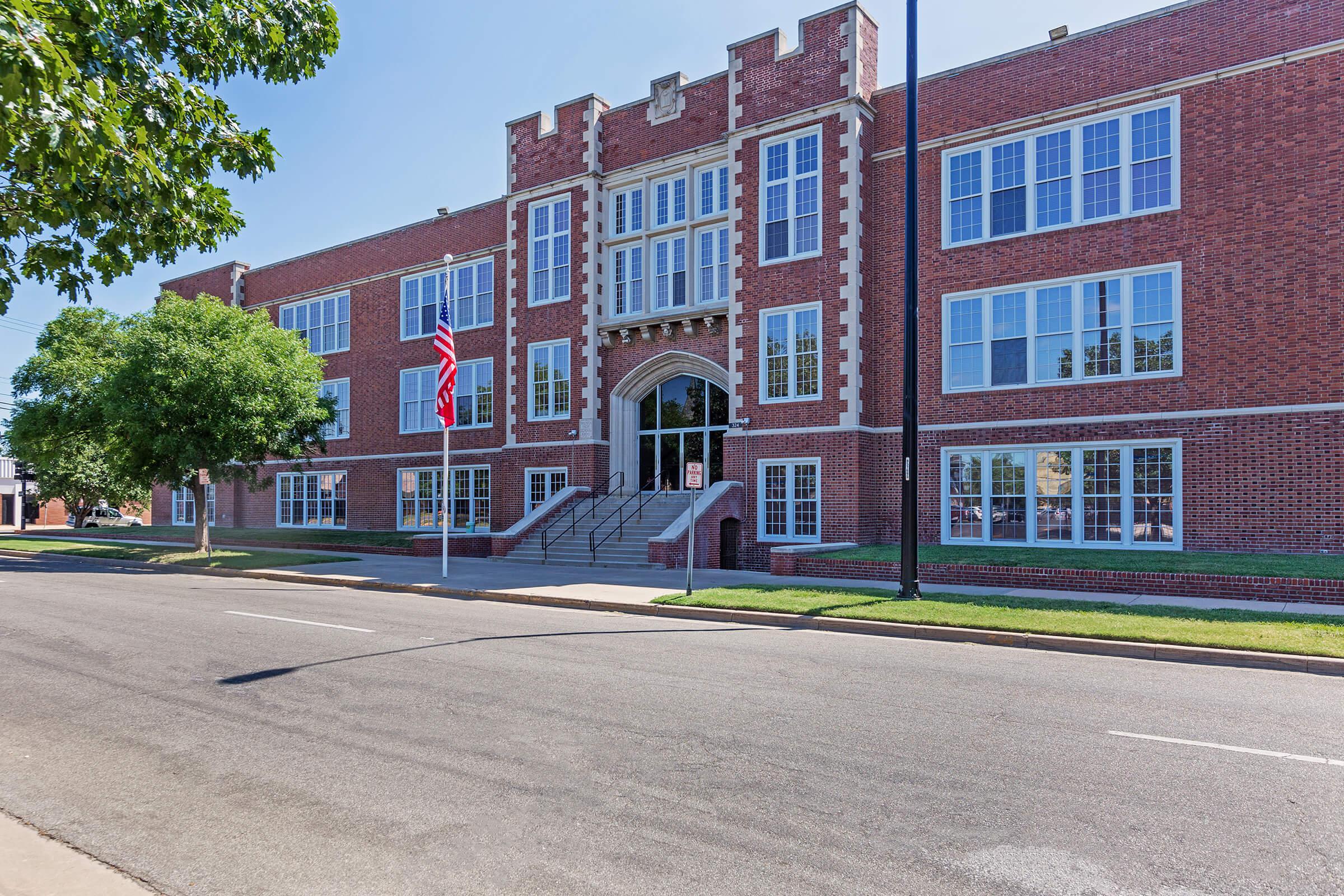 an empty road in front of a brick building