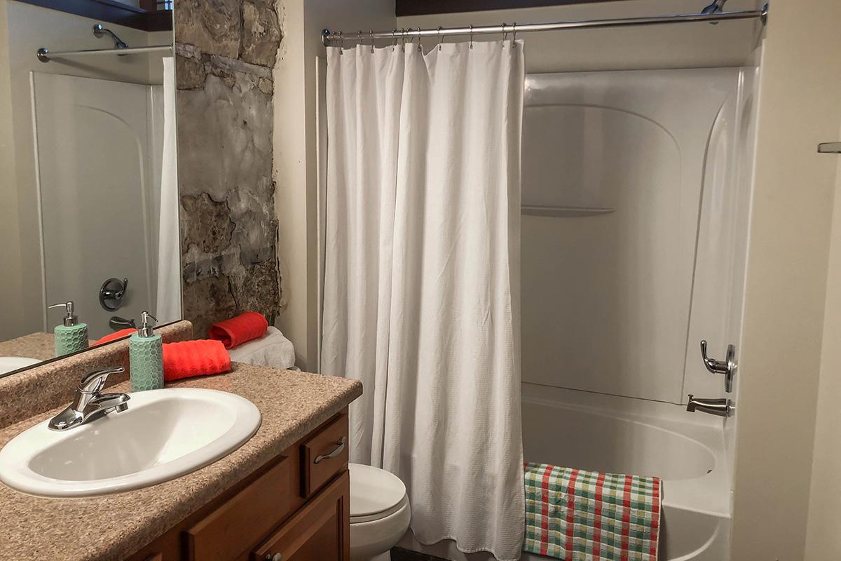 a white sink sitting next to a shower curtain