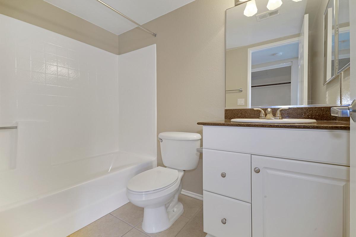 Unfurnished bathroom with white cabinets