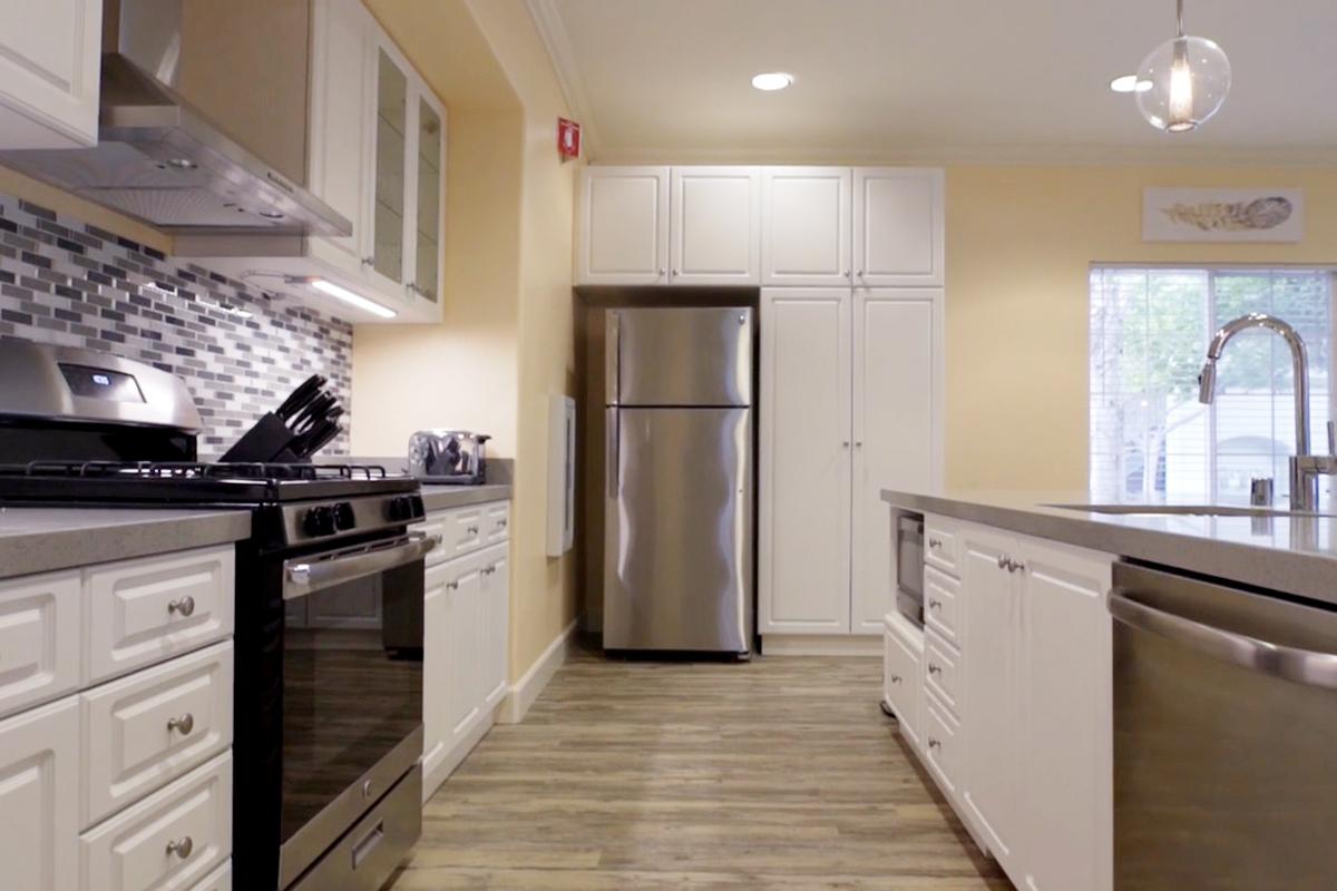 a large kitchen with stainless steel appliances and wooden cabinets