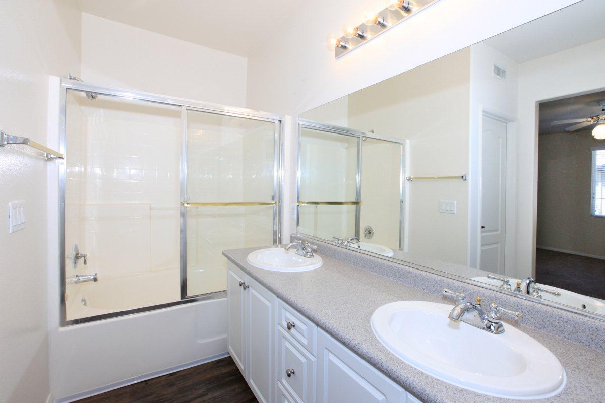 a white sink sitting under a mirror