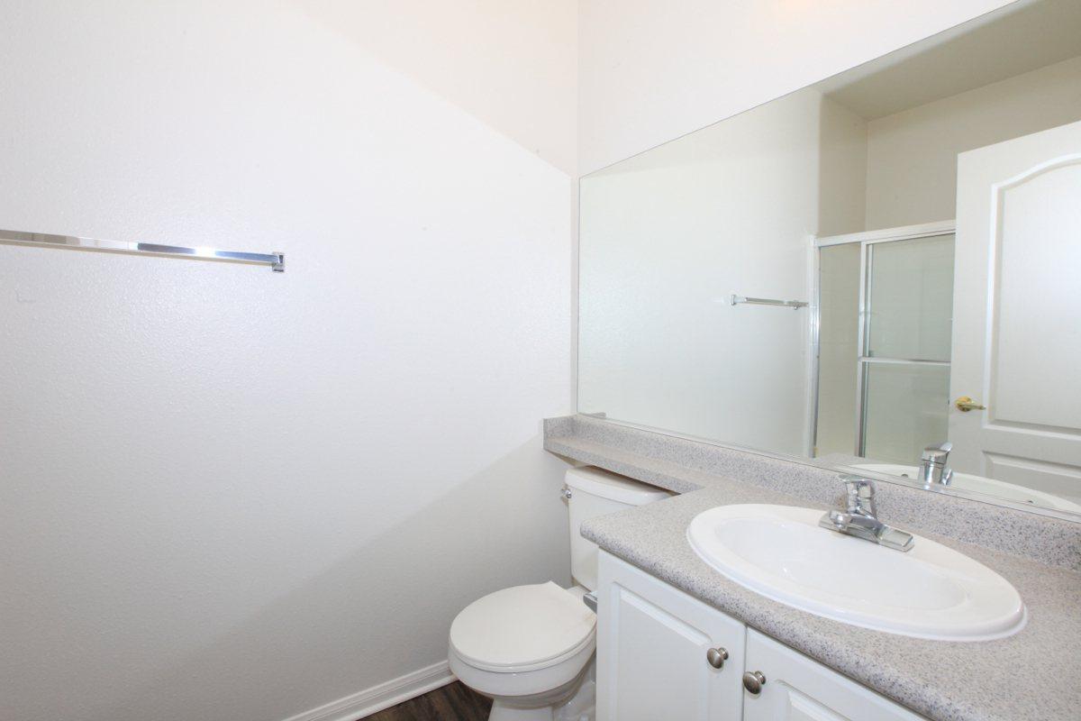 a white sink sitting under a mirror