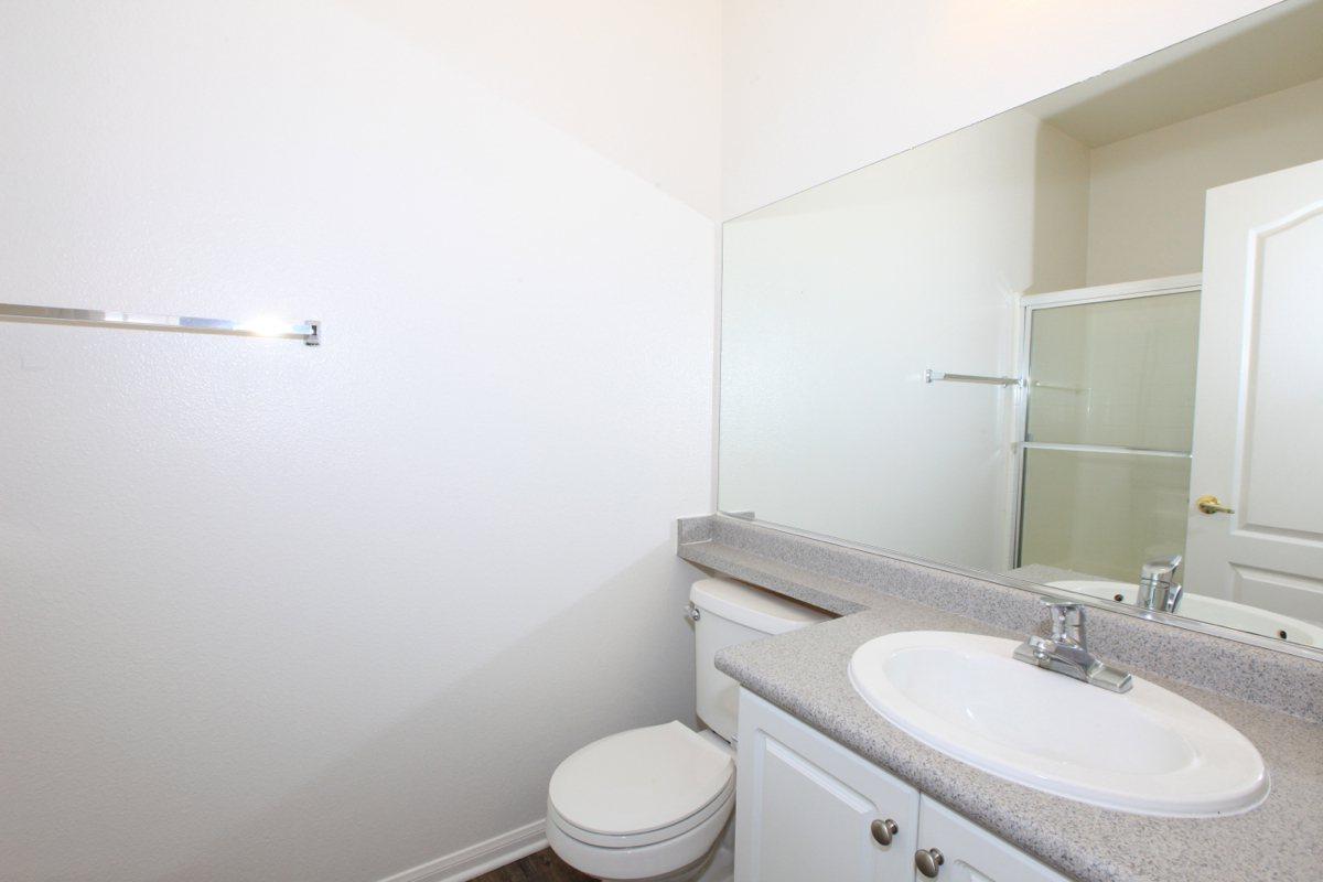 a white sink sitting under a mirror