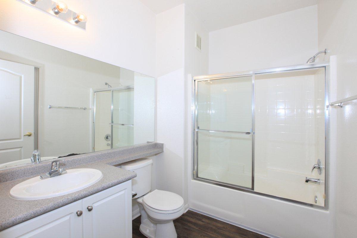 a white sink sitting next to a shower