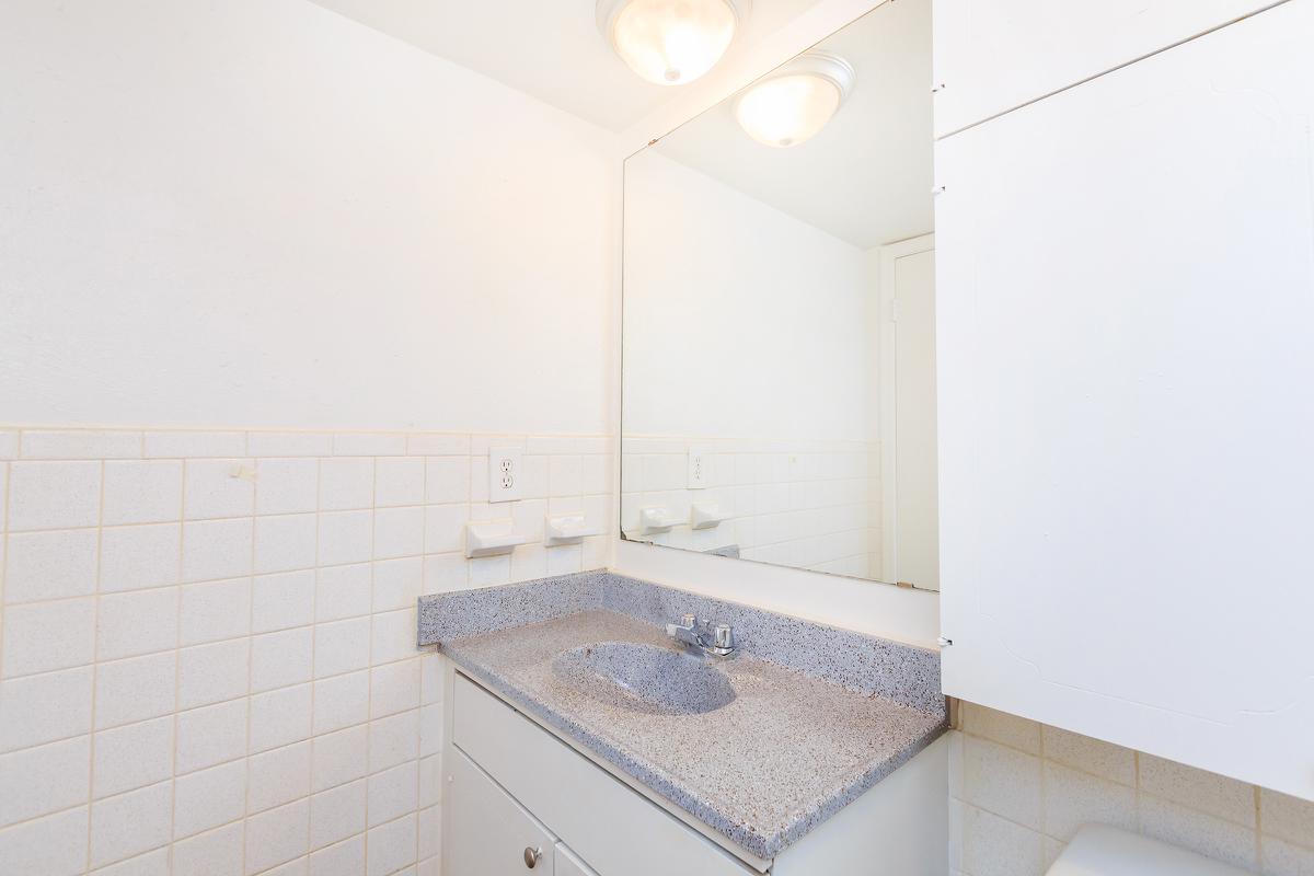 a small white sink in a tiled room