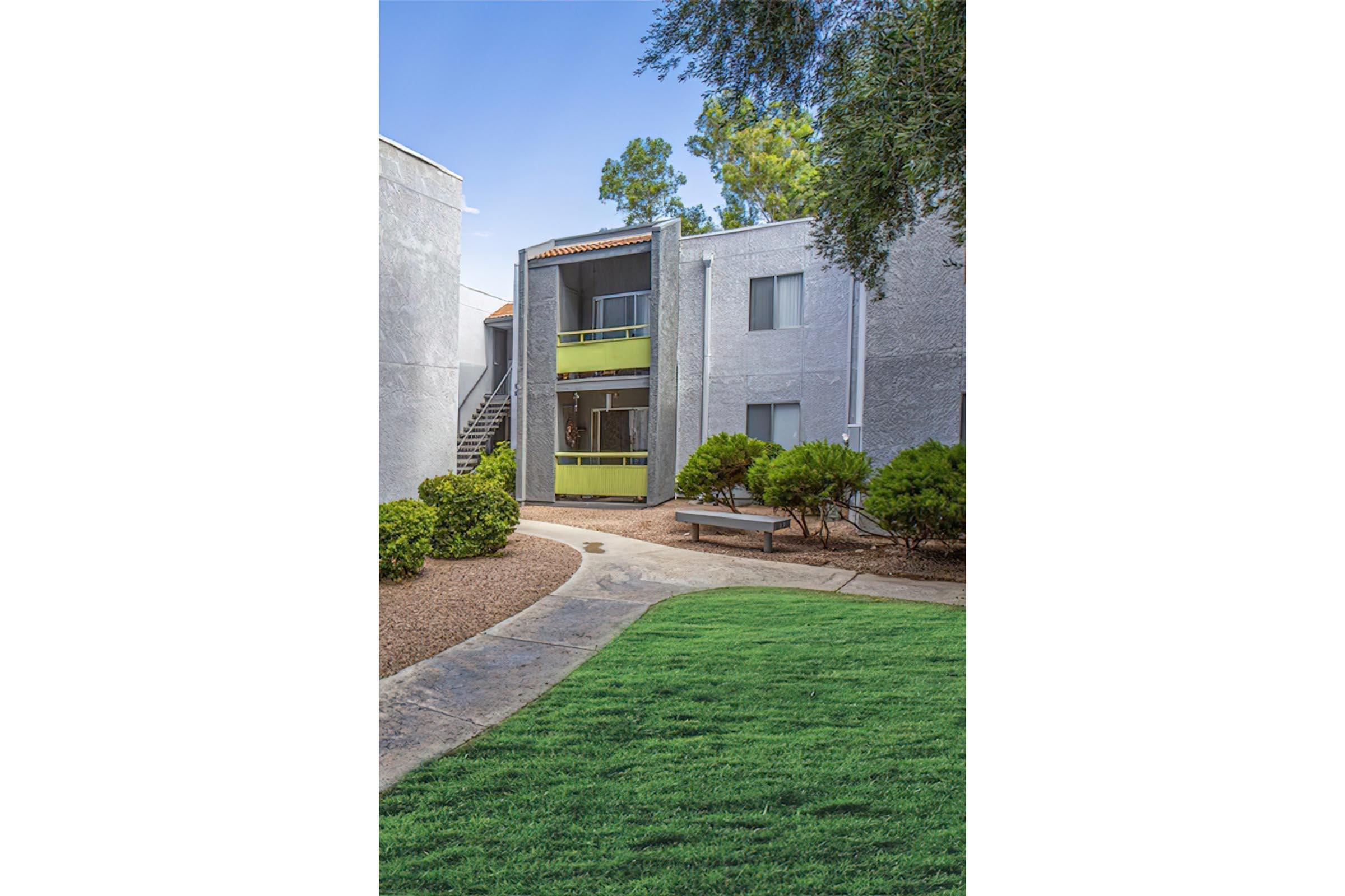 a large brick building with grass in front of a house