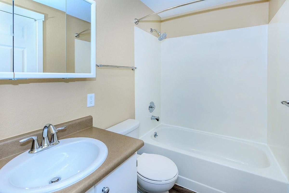 a white sink sitting under a mirror