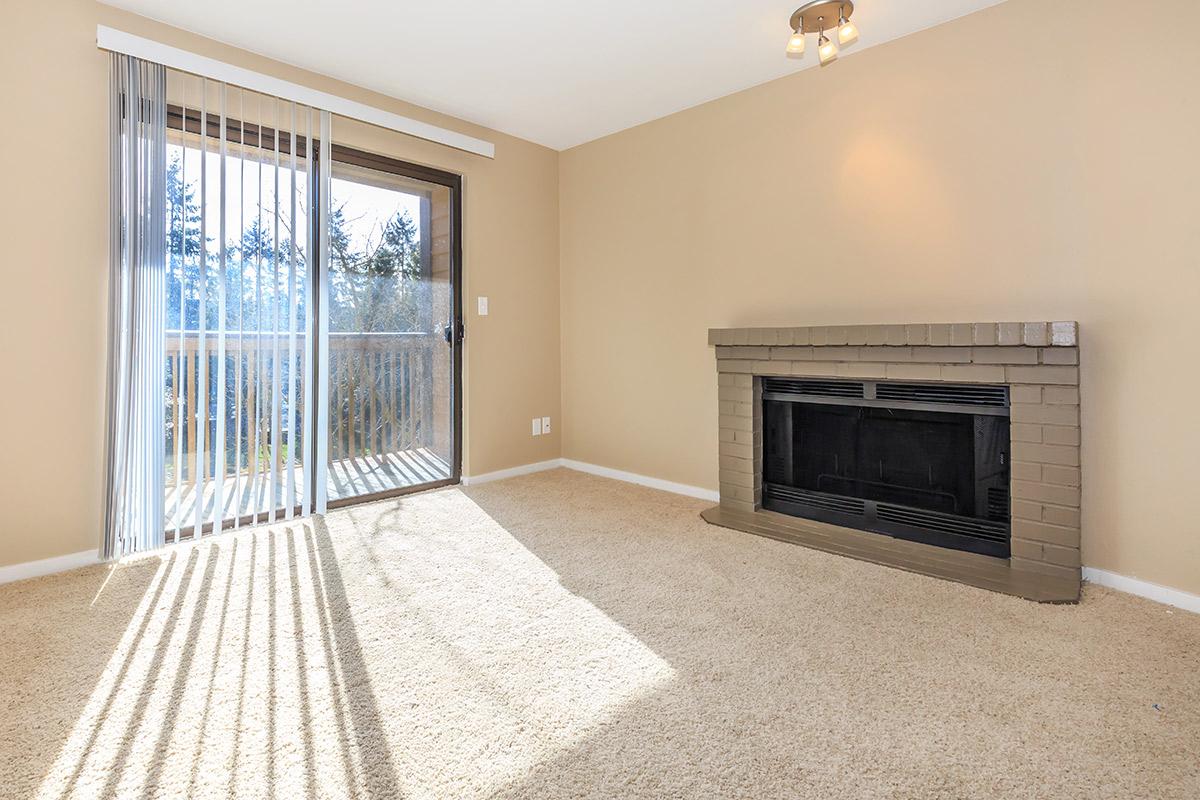 a living room with a fireplace and a large window