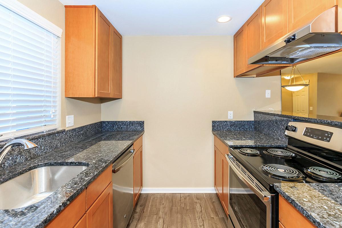 a modern kitchen with stainless steel appliances and wooden cabinets