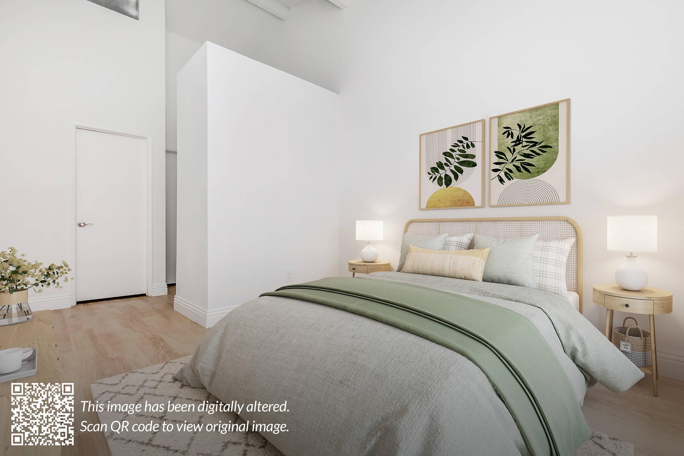 A modern bedroom featuring a large bed with a green throw blanket. There are two decorative wall art pieces above the bed, showcasing leaf designs in soft colors. Each side of the bed has a small nightstand with a lamp. The room has light wood flooring and neutral-colored walls, creating a calming atmosphere.