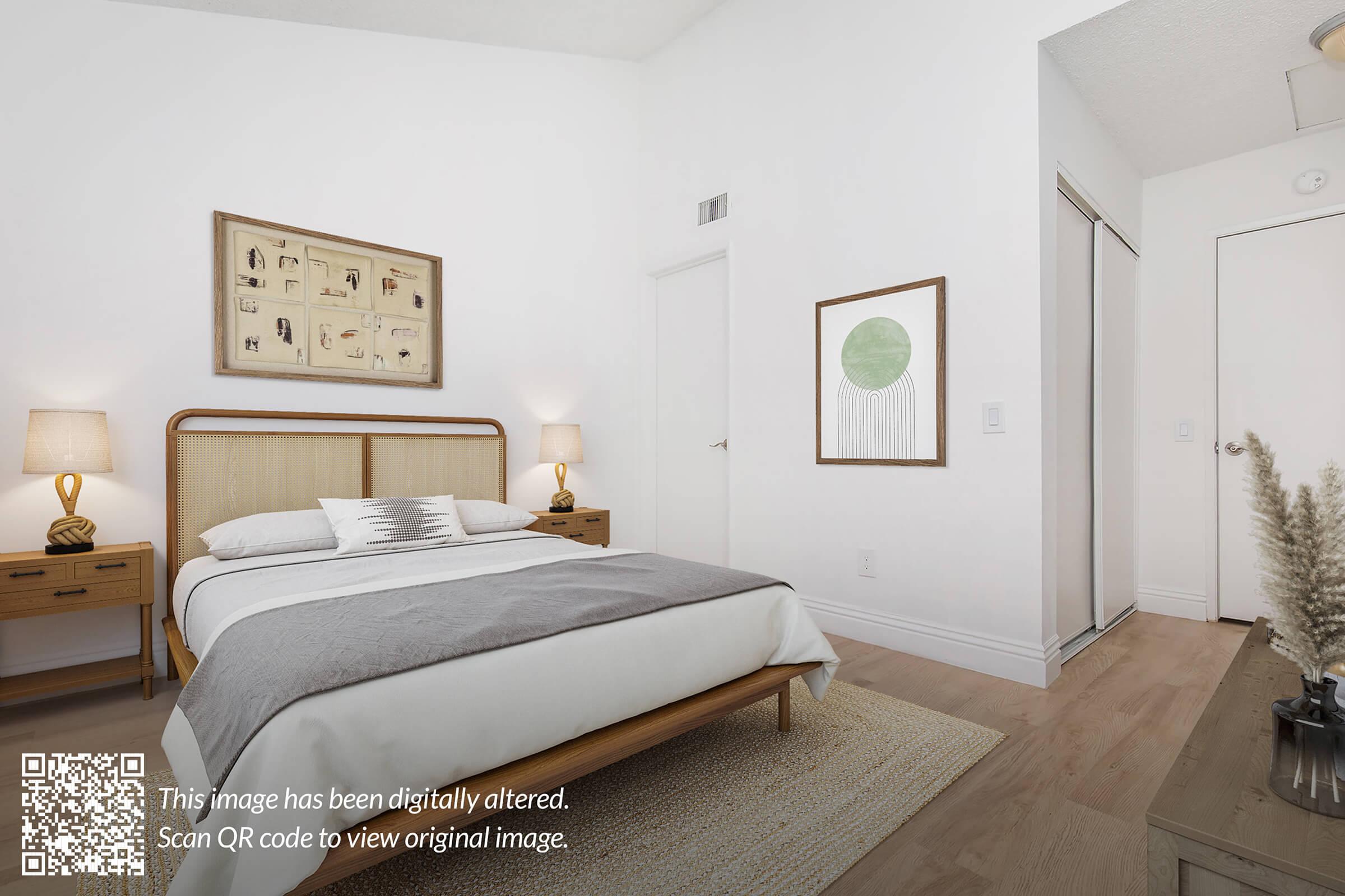 A modern bedroom featuring a light-colored bed with decorative pillows, wooden nightstands on either side, and artwork on the wall. A QR code is in the corner, indicating the image has been digitally altered. The room has a minimalistic design with neutral tones and wooden flooring.
