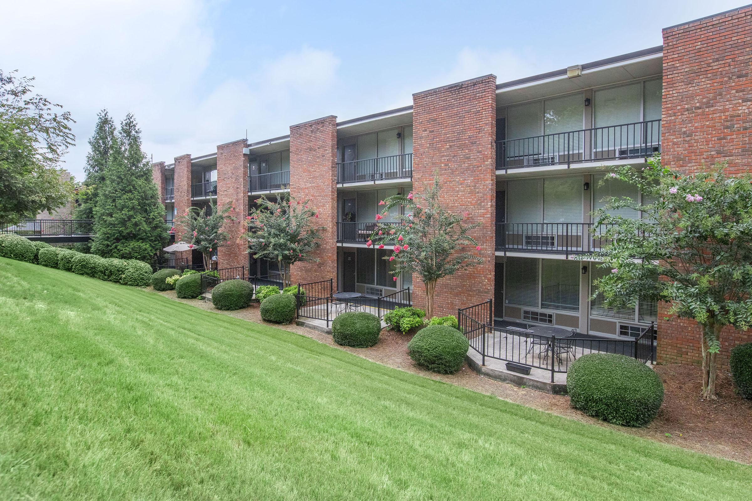 a large lawn in front of a brick building