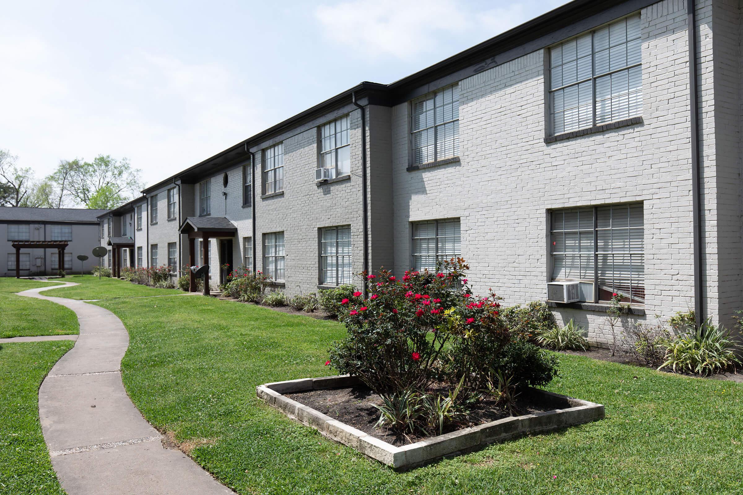 a large lawn in front of a brick building