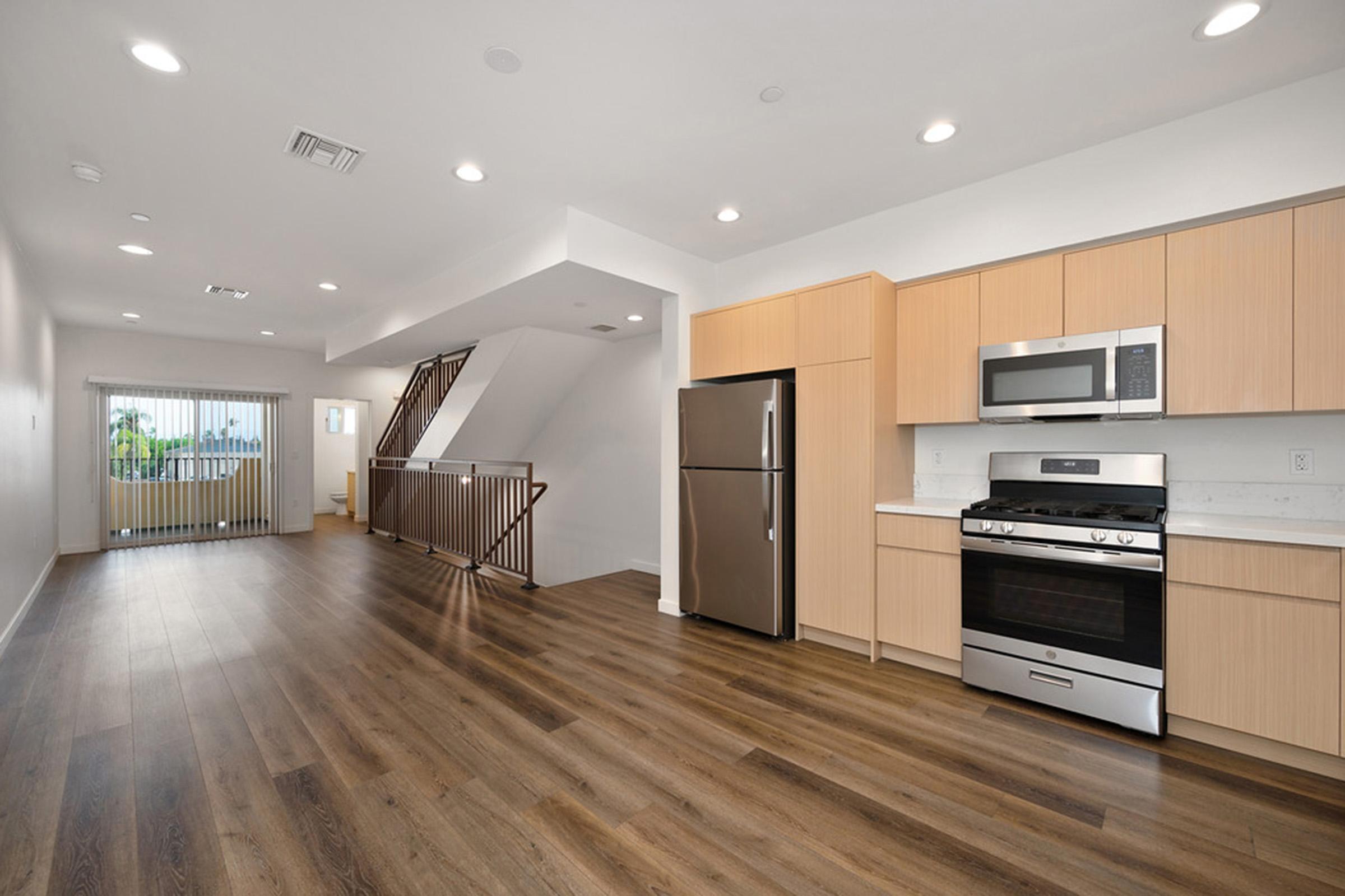 a kitchen with a wood floor and stainless appliances