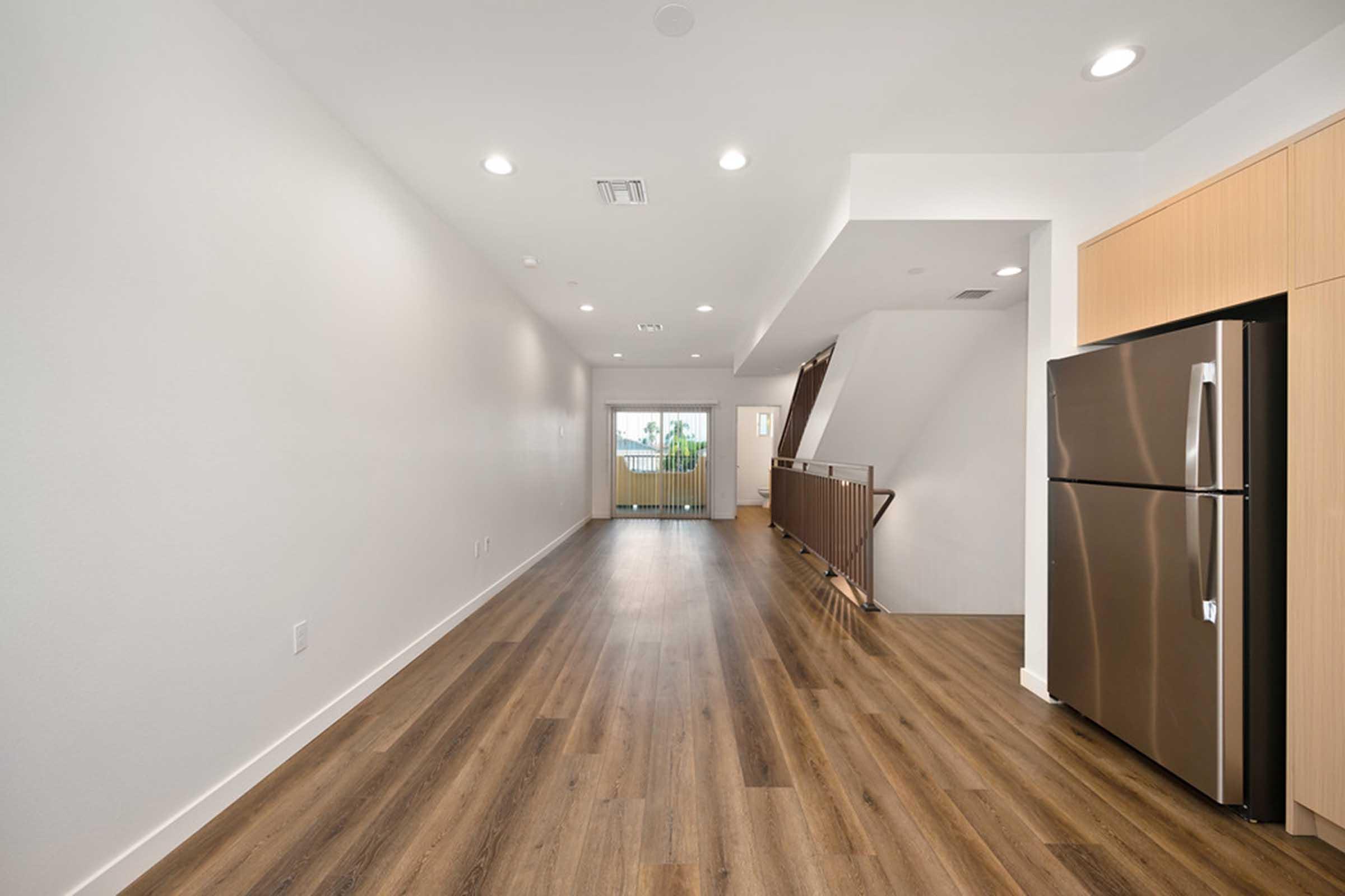 a room with a wood floor and refrigerator