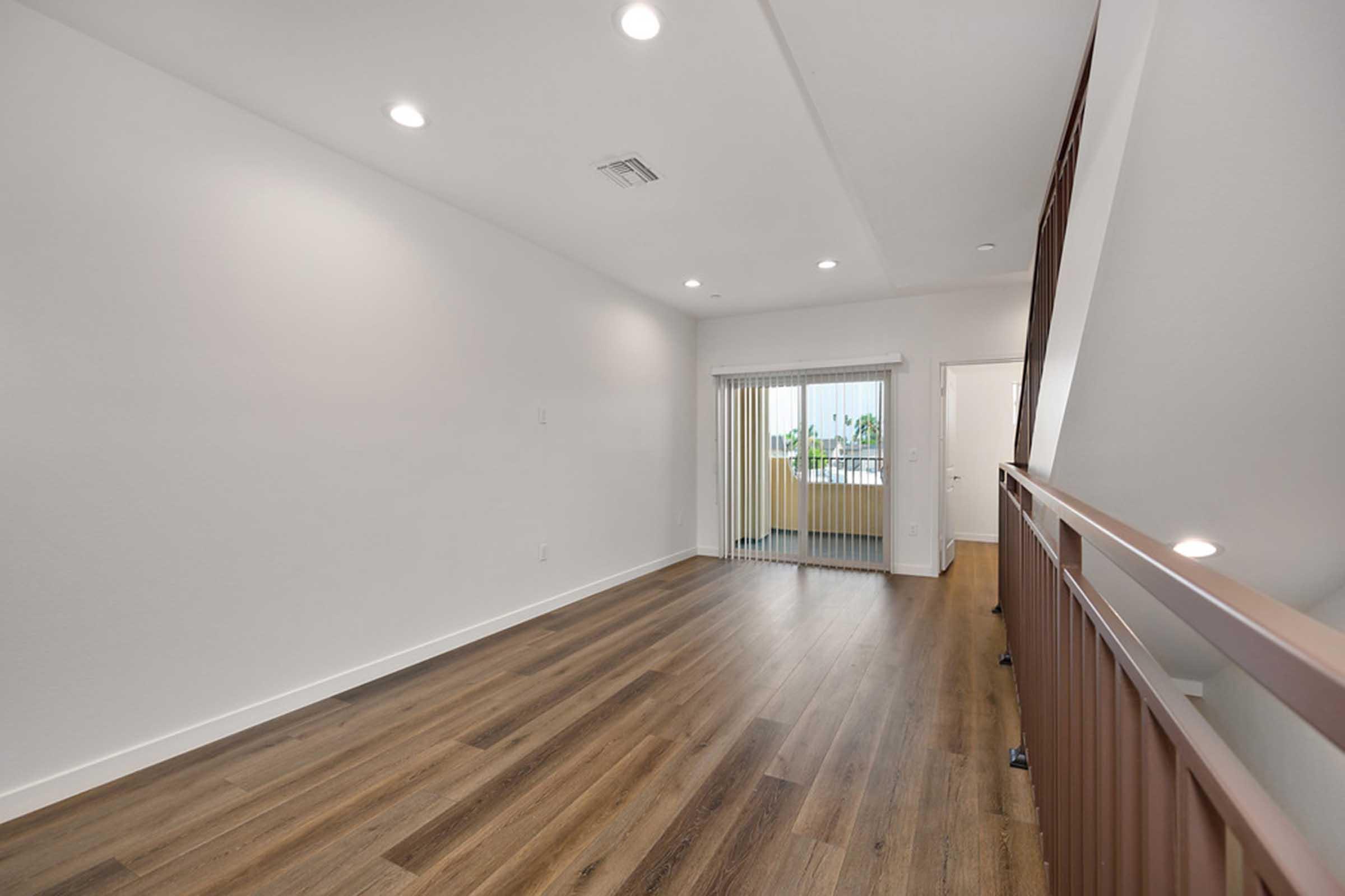 a room with a wooden floor and staircase