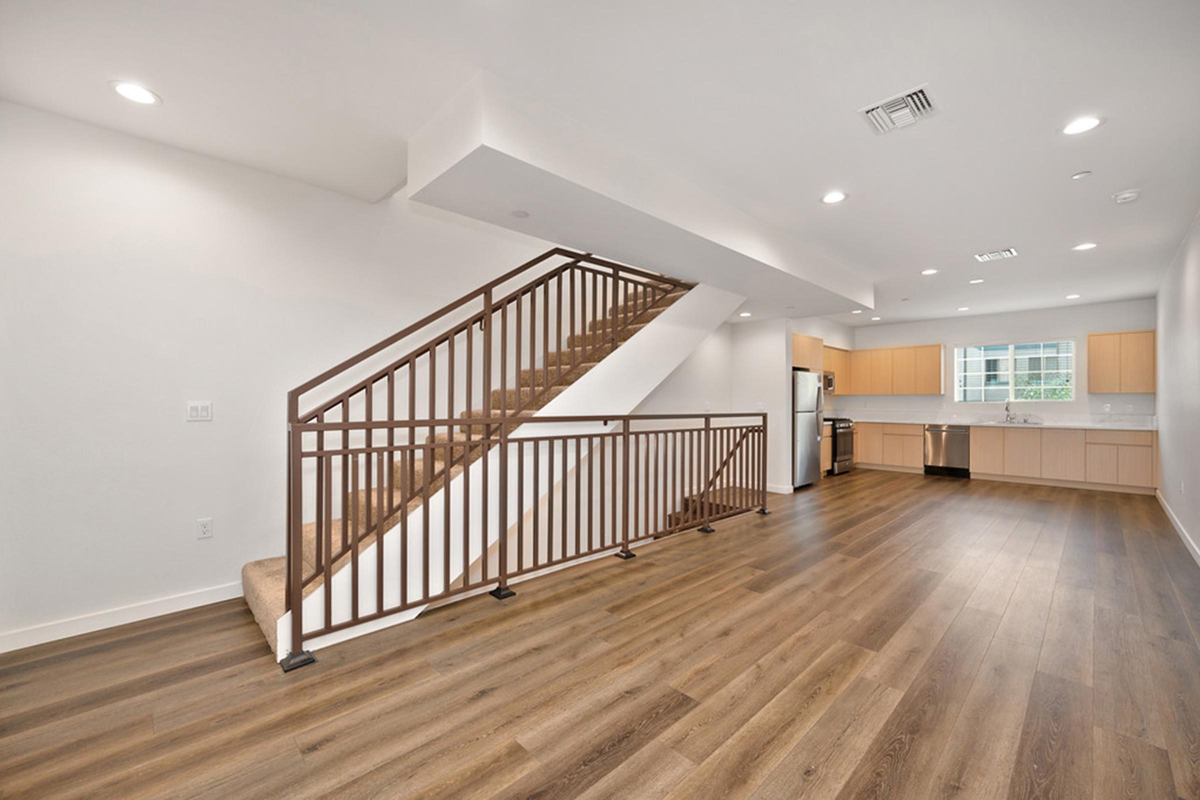 a room with a wood floor and modern staircase