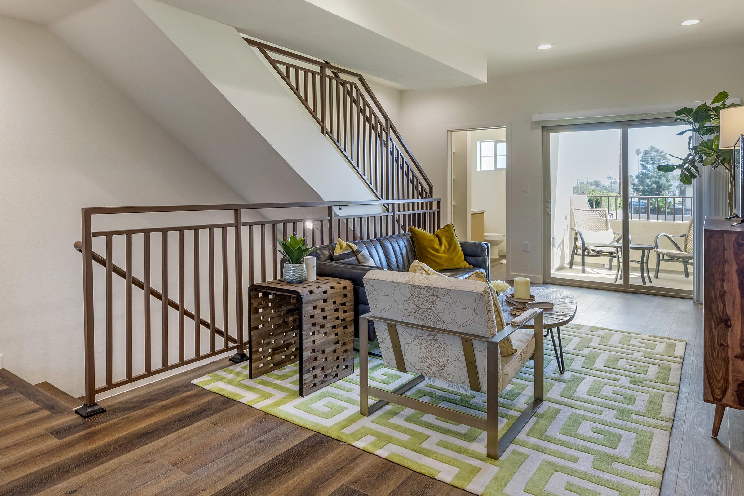 a living room filled with furniture and a staircase