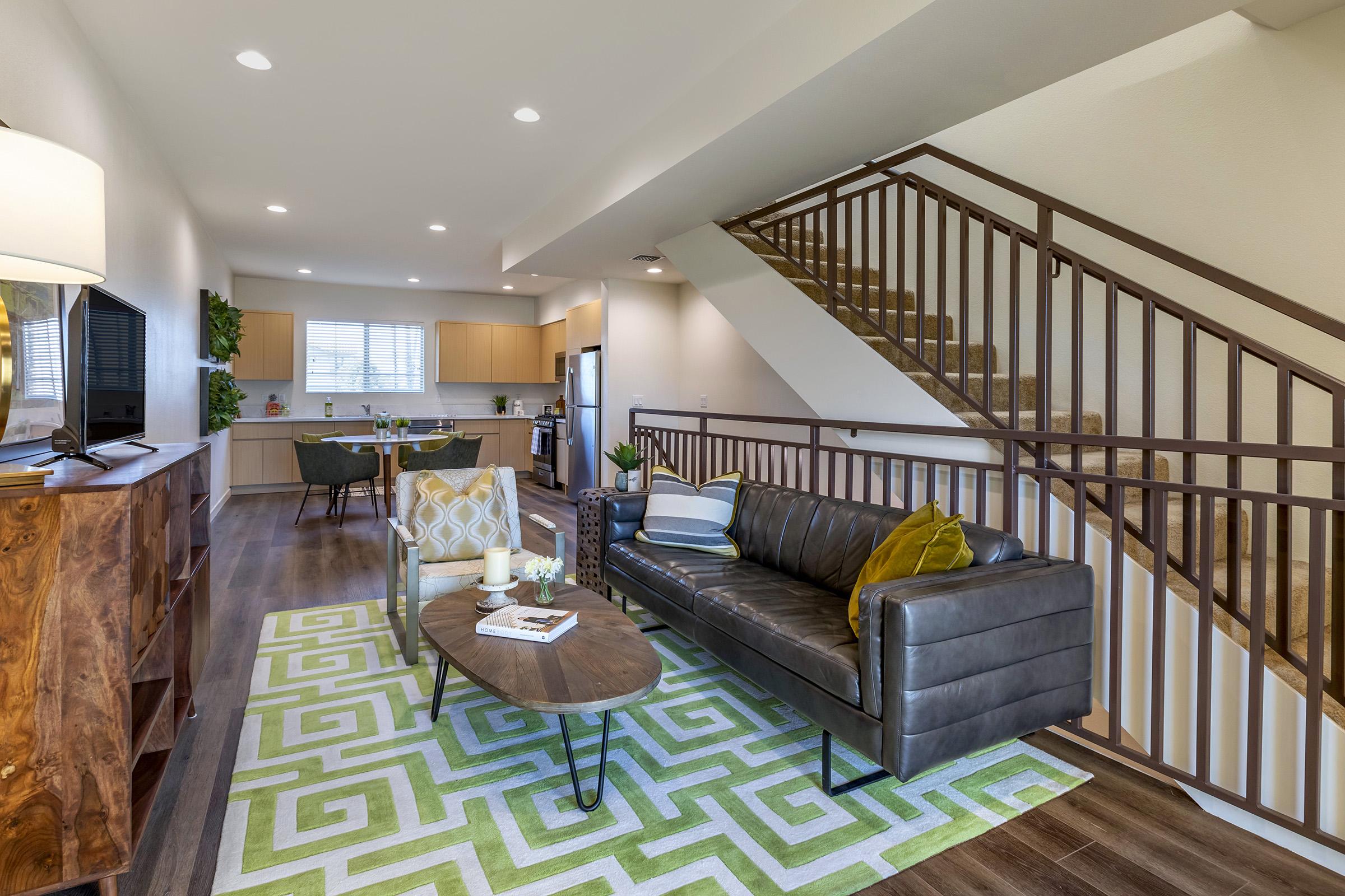 a living room with furniture and a modern staircase