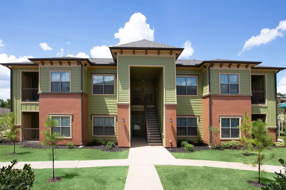 a house with a lawn in front of a brick building