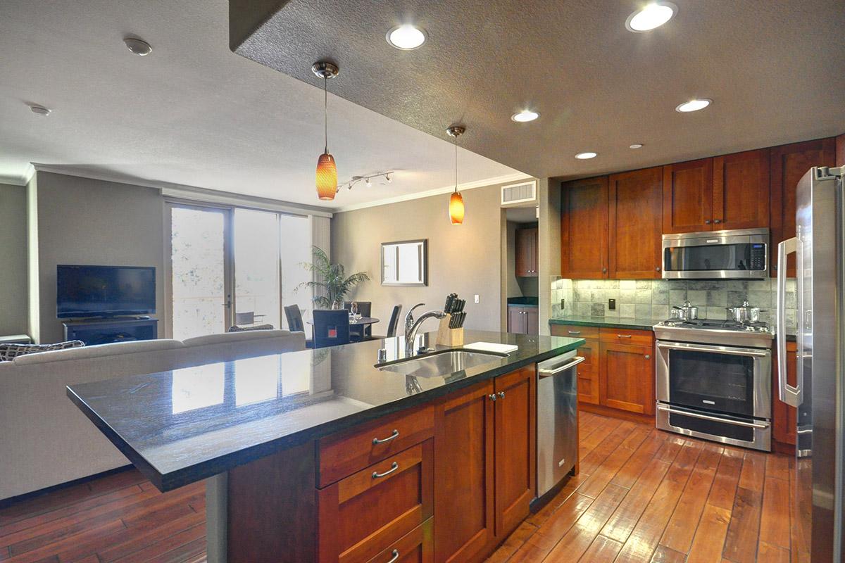 a modern kitchen with stainless steel appliances and wooden cabinets