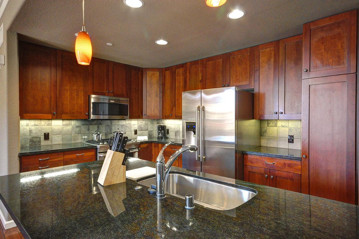 a large kitchen with stainless steel appliances and wooden cabinets